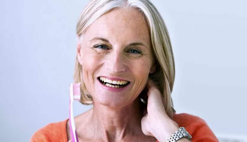 Laughing Elderly Woman Brushing Her Teeth | Restorative Dentistry in West Liberty, IA, North Liberty, IA and Muscatine, IA | Gentle Family Dentists